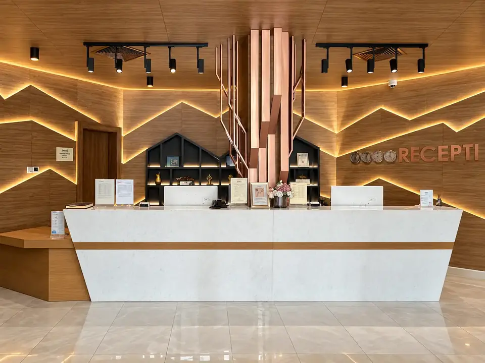 Рецепцията на Santé SPA Hotel, Велинград: бял каменен плот, дървена стена с LED силует на планина и медна скулптура